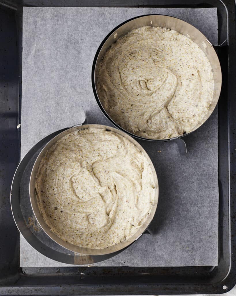 two cake rings with pistachio dacquoise batter in them, ready to bake.