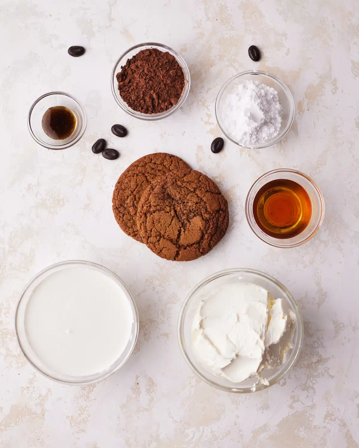 ingredients to make tiramisu cookies - coffee cookies, mascarpone, amaretto, powdered sugar, vanilla, whipping cream and cocoa powder. 