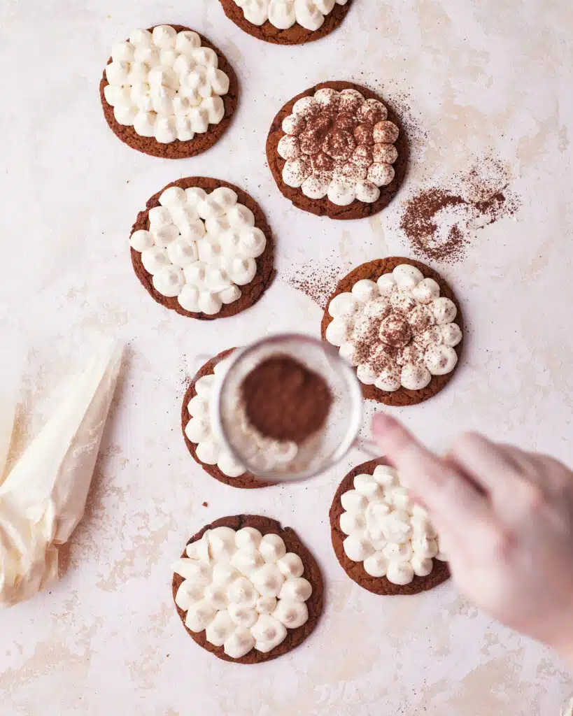 Tiramisu cookies being dusted with cocoa powder.
