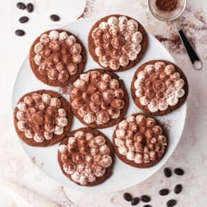Tiramisu cookies on a plate, dusted with cocoa powder.