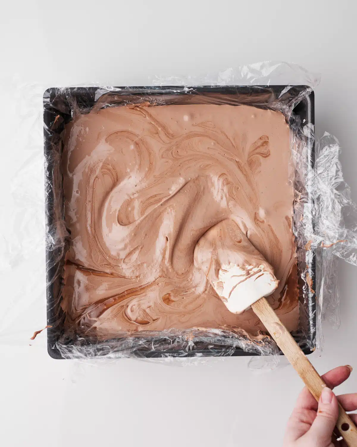 Chocolate marshmallow being poured into cake pan to set. 