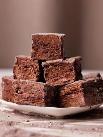chocolate marshmallow squares in a pile on a small plate.