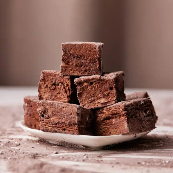 chocolate marshmallow squares in a pile on a small plate.