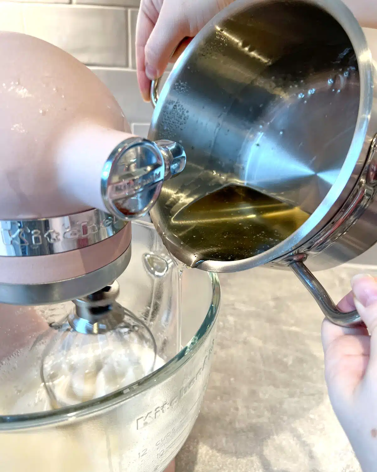 Pouring sugar syrup into gelatine to make chocolate marshmallows.