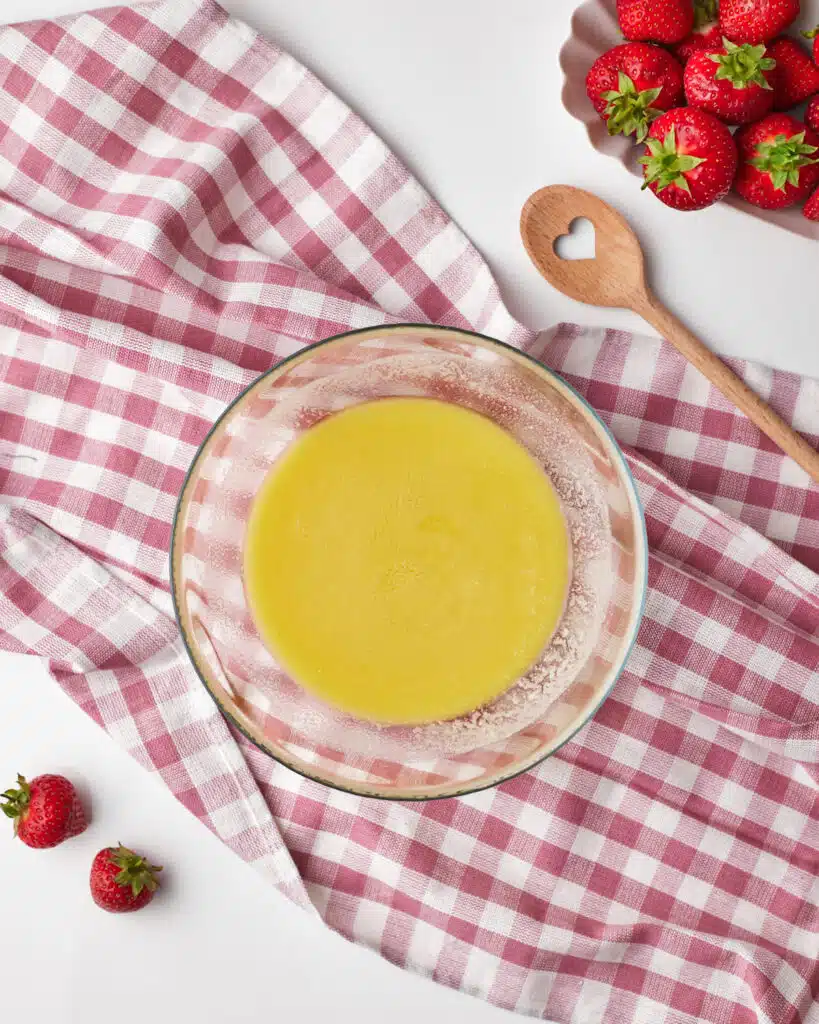 process shot for strawberry brownies, white chocolate and butter melted together in a bowl.