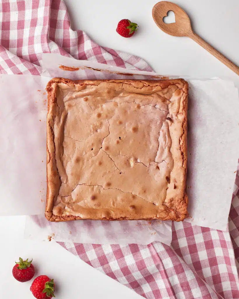 process shot for strawberry brownies, baked strawberry brownies out of the oven and cooling.