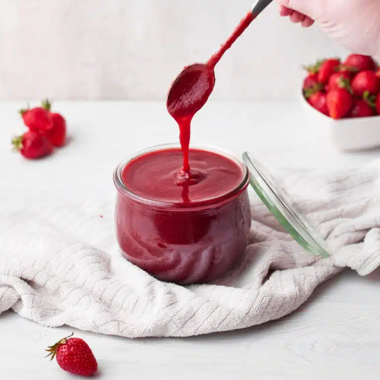 homemade strawberry coulis (strawberry puree) in a glass jar.