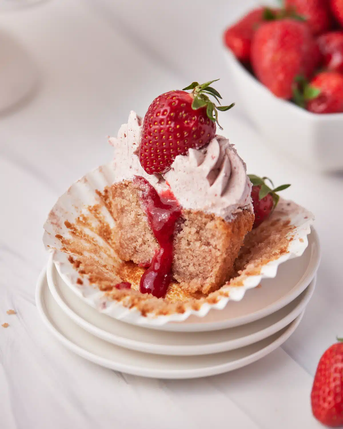 strawberry cupcake with strawberry coulis filling - cut in half to show filling oozing out. 