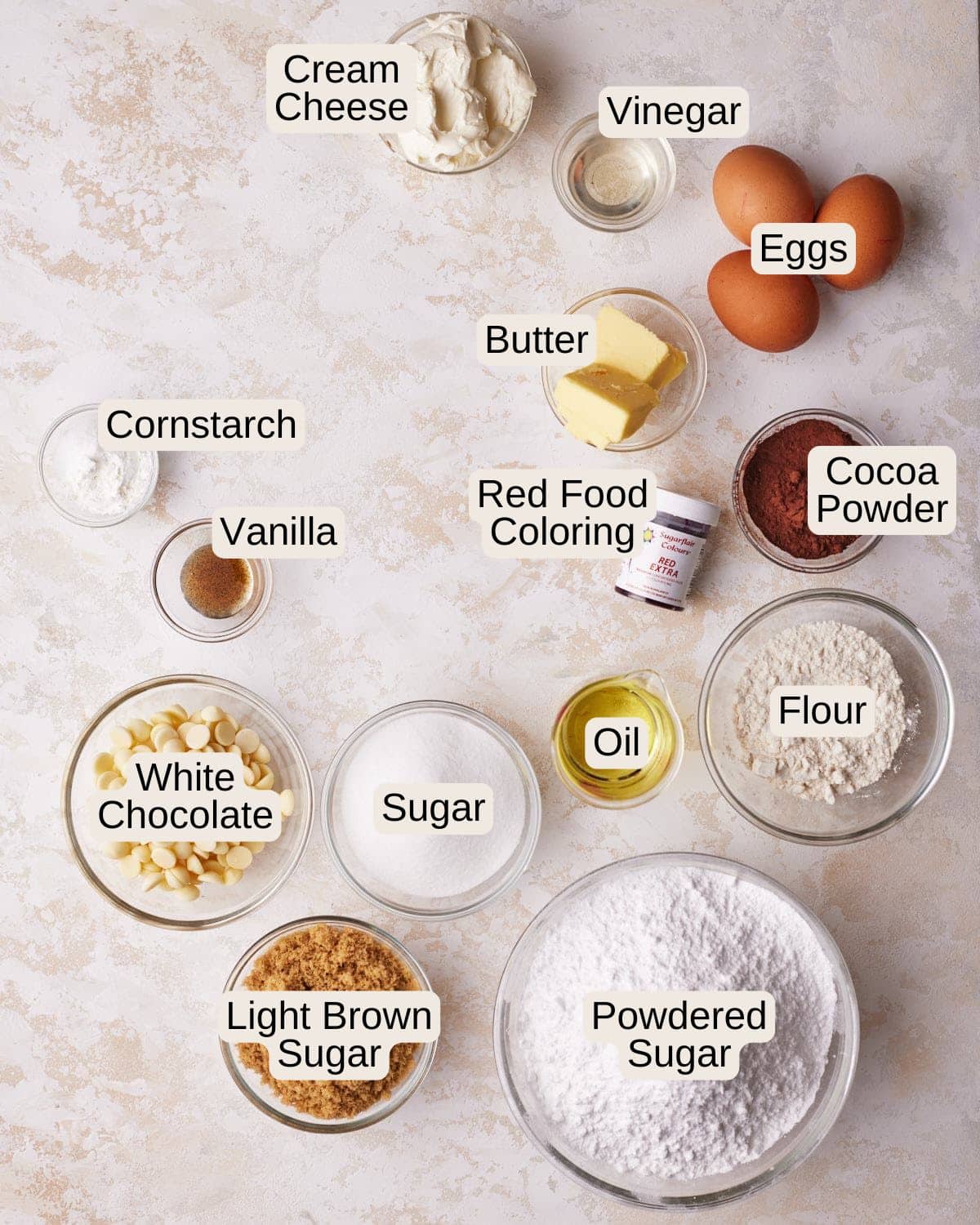 Ingredients to make red velvet brownies - flour, butter, sugar, light brown sugar, eggs, vegetable oil, vinegar, salt, cocoa powder and red food coloring.