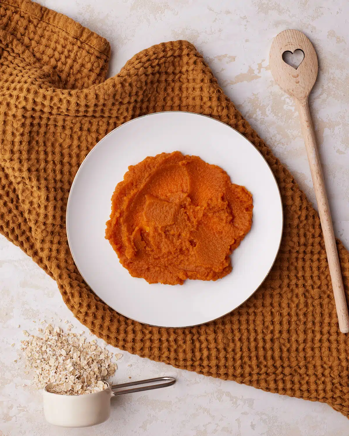 pumpkin puree on a plate before it is blotted to remove the moisture to make pumpkin oatmeal cookies. 