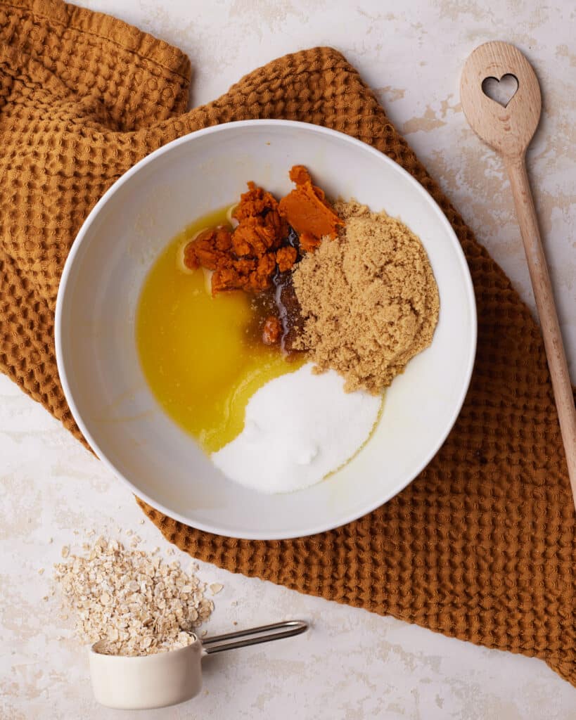 Process shot of ingredients in a bowl to make pumpkin oatmeal cookies.