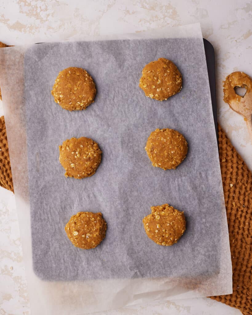 raw pumpkin oatmeal cookie dough on a baking sheet, ready to be baked.