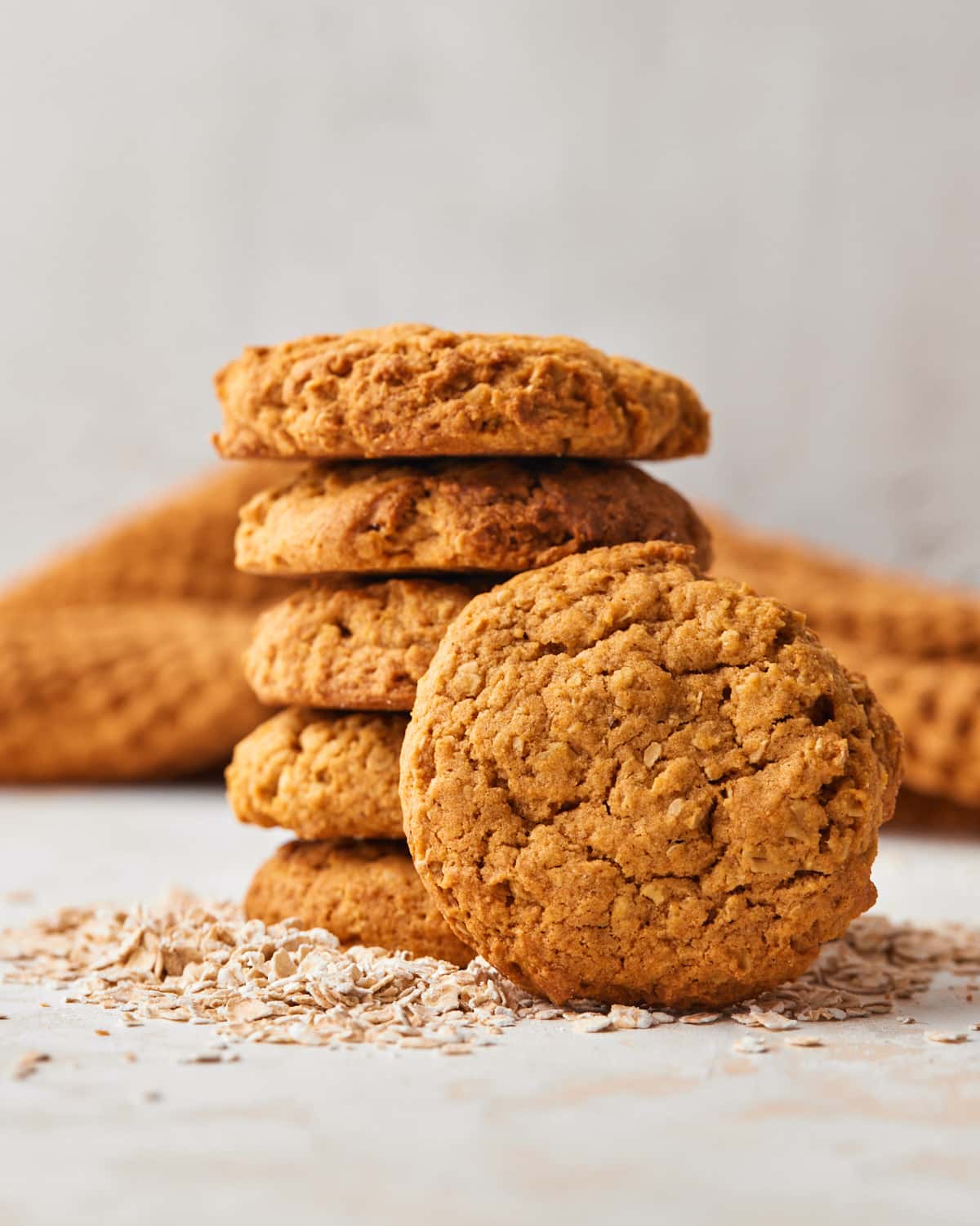 pumpkin oatmeal cookies stacked up, with one leaning against the side.