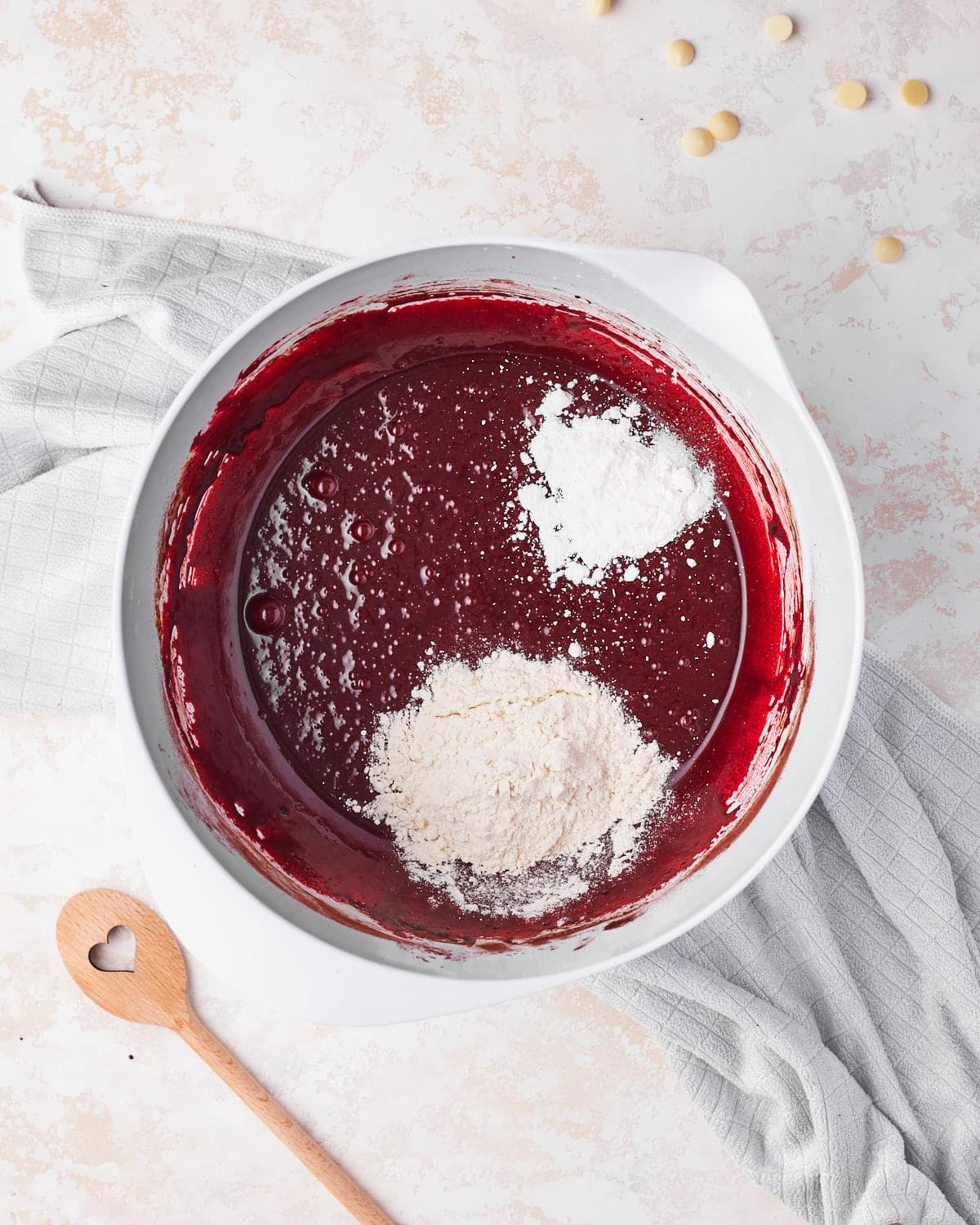 flour being mixed into red velvet brownie batter. 