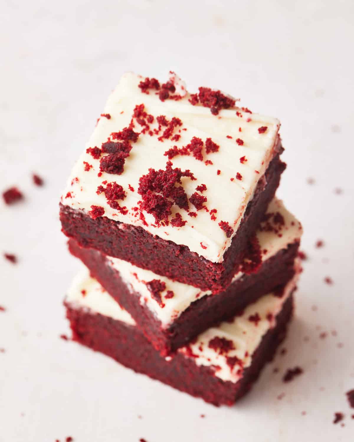 stack of red velvet brownies shot from above to show the cream cheese frosting.