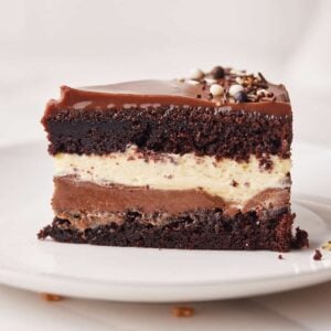 Slice of homemade tuxedo cake showing the layers of chocolate cake, dark chocolate mousse, white chocolate mousse, and ganache.