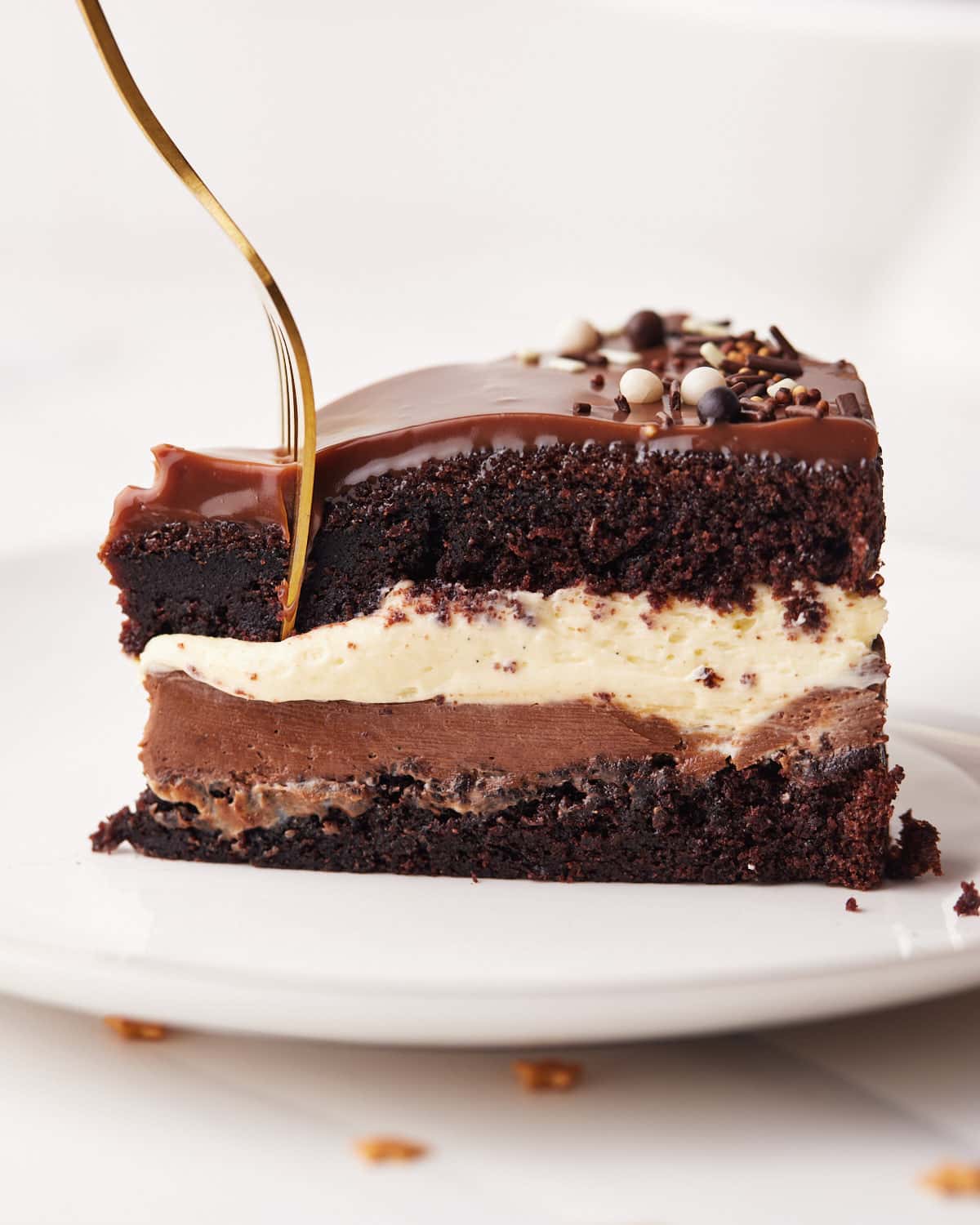 slice of tuxedo cake from the side, with a fork about to take a bite.
