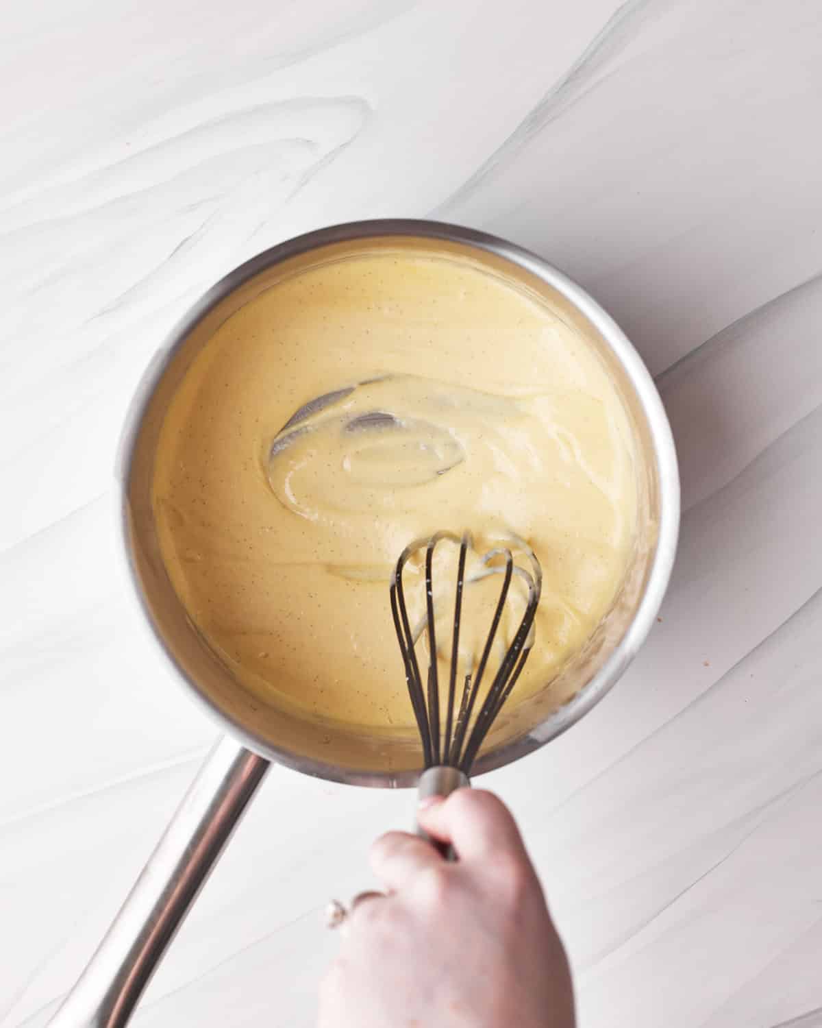 process shot showing proper thickness for custard mixture for chocolate mousse in tuxedo cake. 