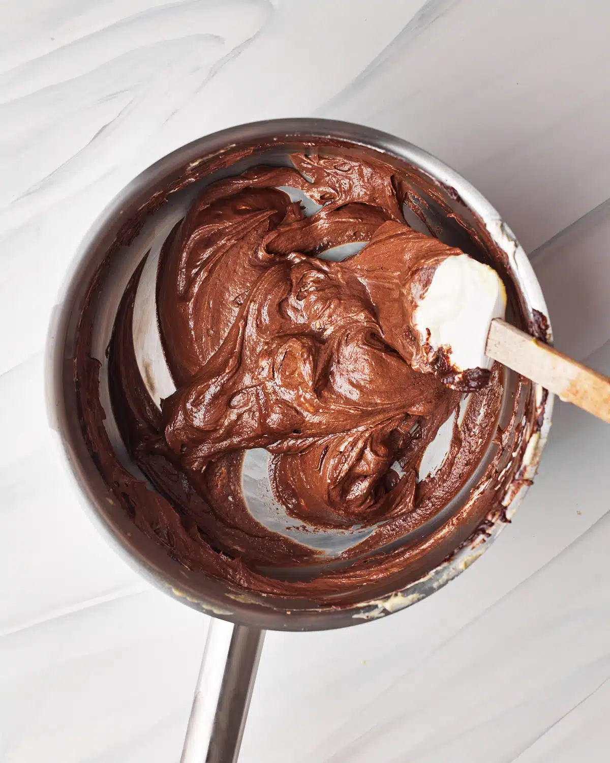 folding whipped cream into chocolate custard to make tuxedo cake.