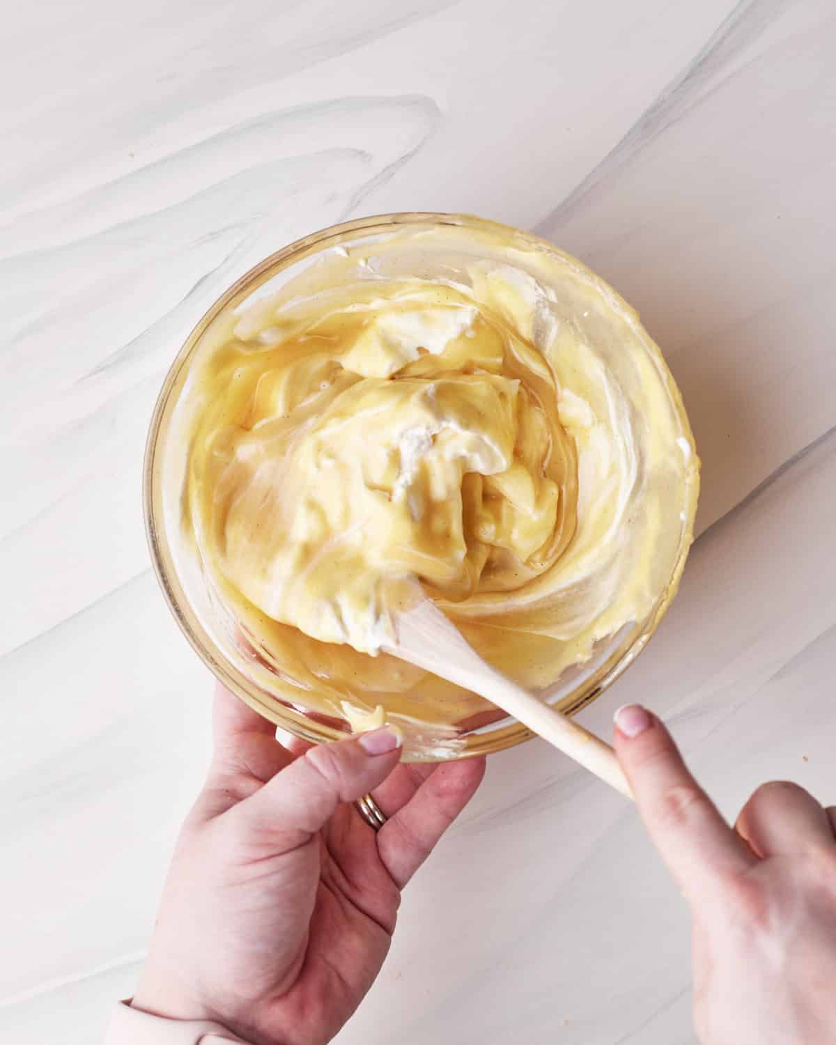 Folding whipped cream into white chocolate mousse for tuxedo cake. 