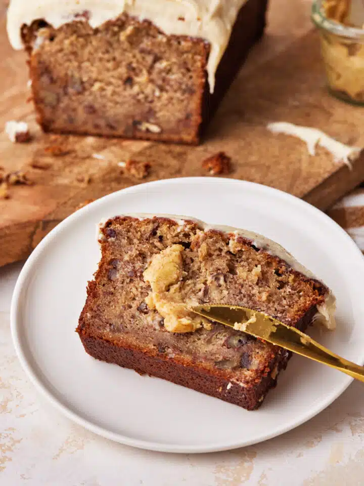 a slice of brown butter banana bread with brown butter smeared on top.