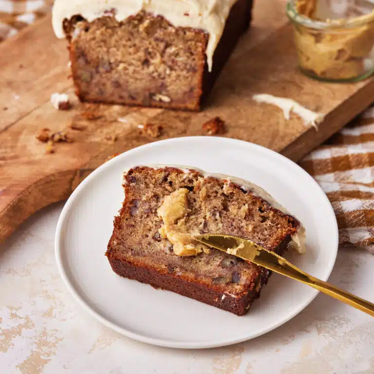 a slice of brown butter banana bread with brown butter smeared on top.