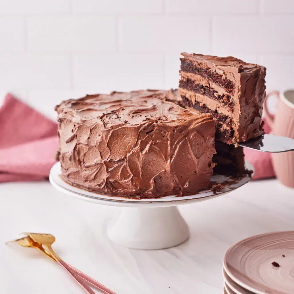 Chocolate Fudge Cake with a slice being taken out.