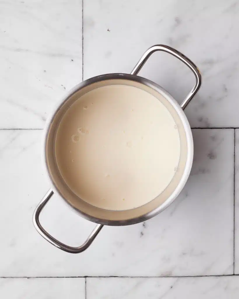 Heavy cream in a saucepan to make chocolate ganache for chocolate fudge cake.