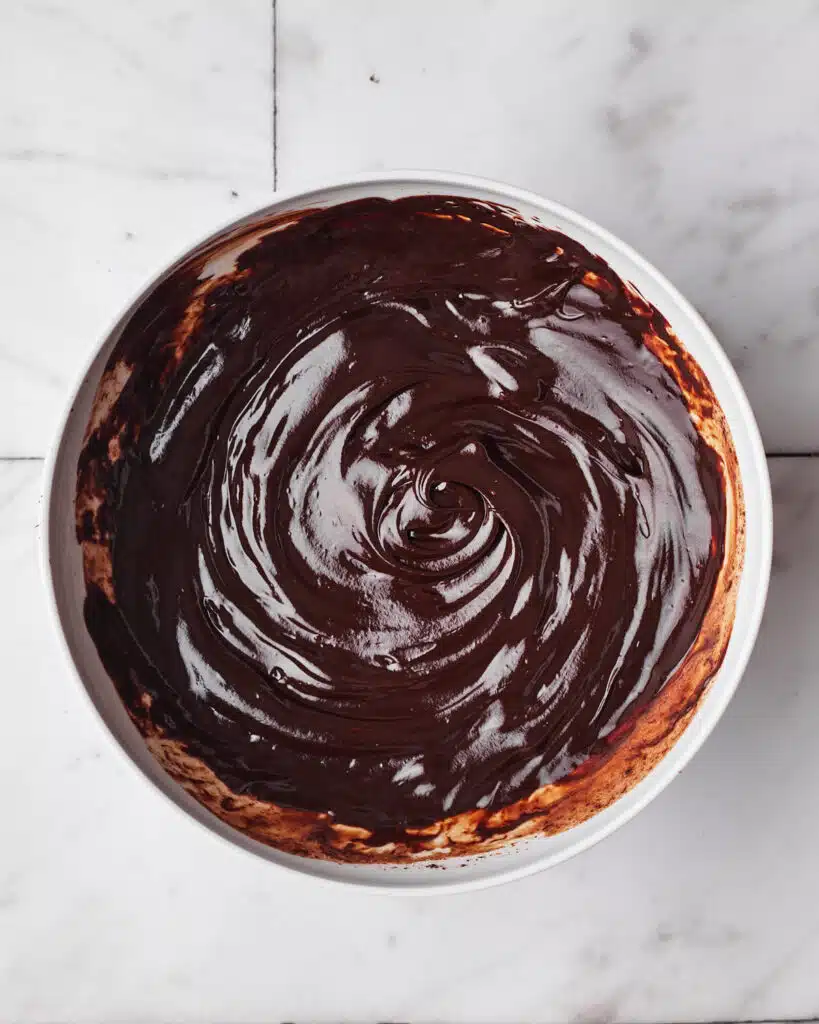 chocolate ganache in a bowl ready to make frosting for chocolate fudge cake.