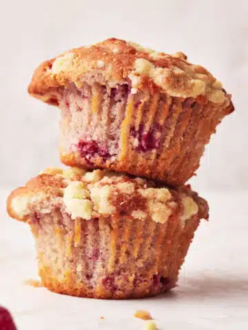 Two raspberry muffins stacked on top of each other.