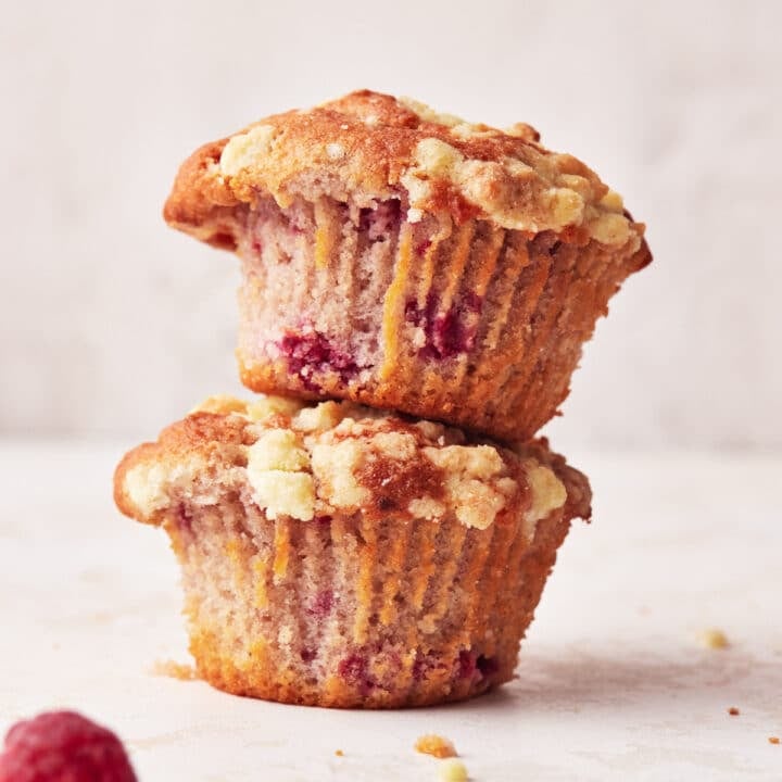 Two raspberry muffins stacked on top of each other.