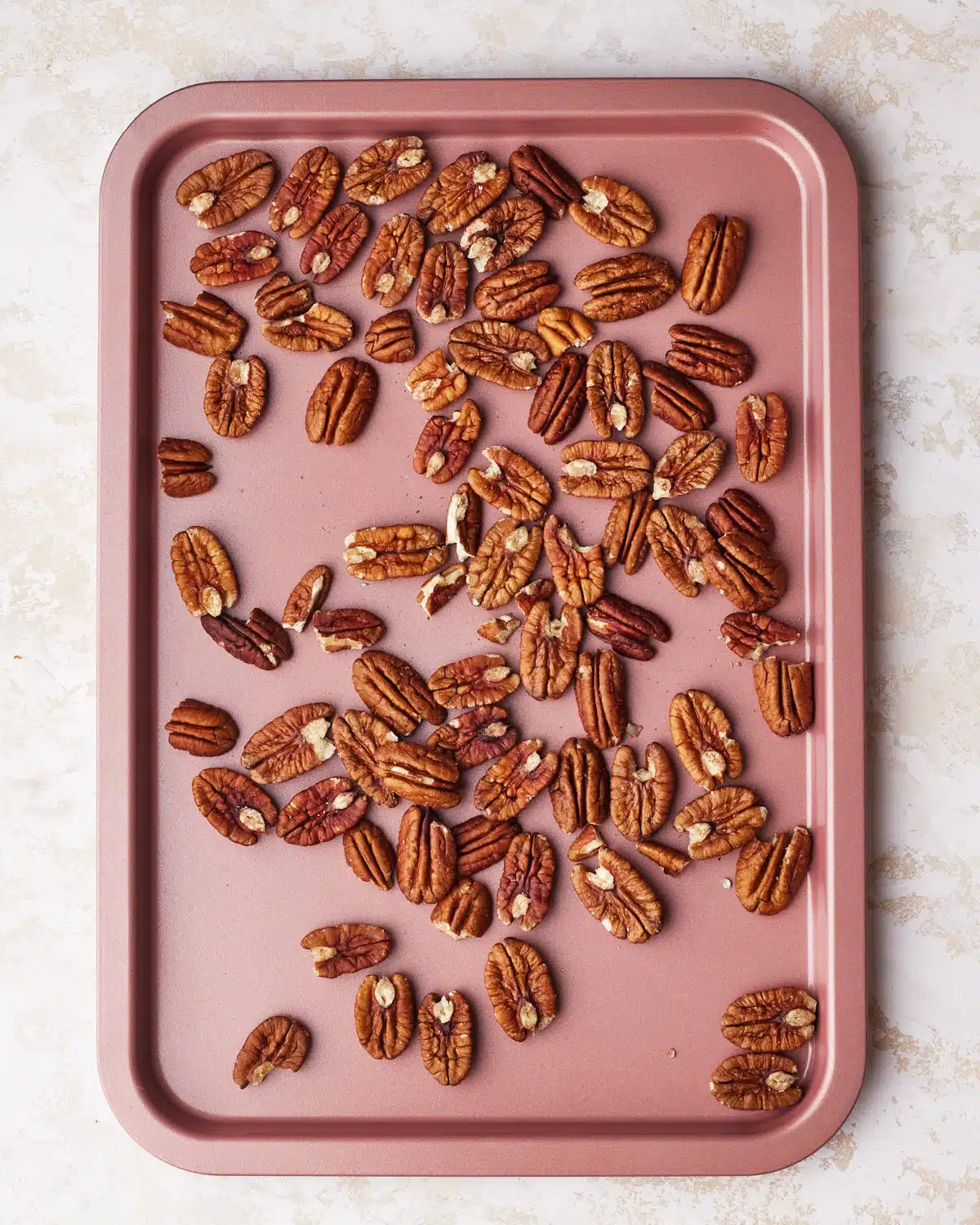 pecans on a baking sheet ready to be toasted for german chocolate frosting.