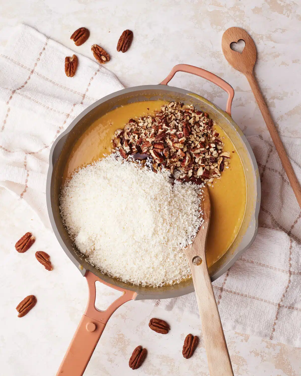 Coconut and pecans being added to german chocolate frosting recipe. 