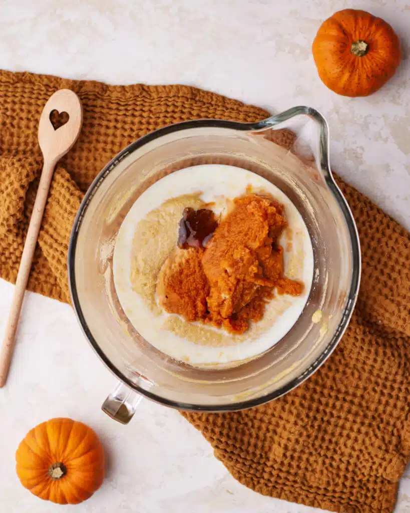 adding wet ingredients to pumpkin bundt cake batter.