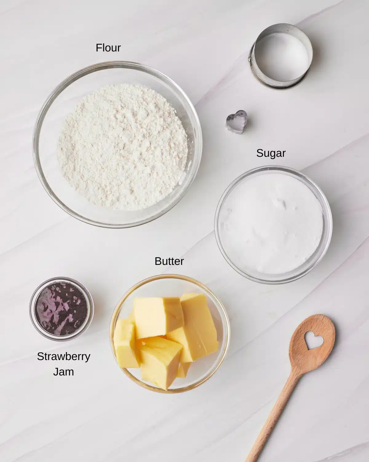 Ingredients to make homeamde jammie dodgers - butter, sugar, flour and strawberry jam. 