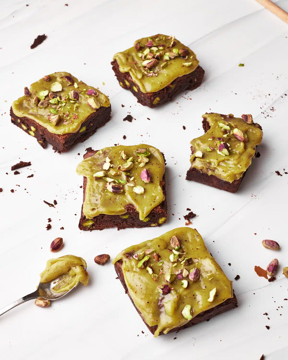 Pistachio brownies with pistachio ganache and chopped pistachios on top.