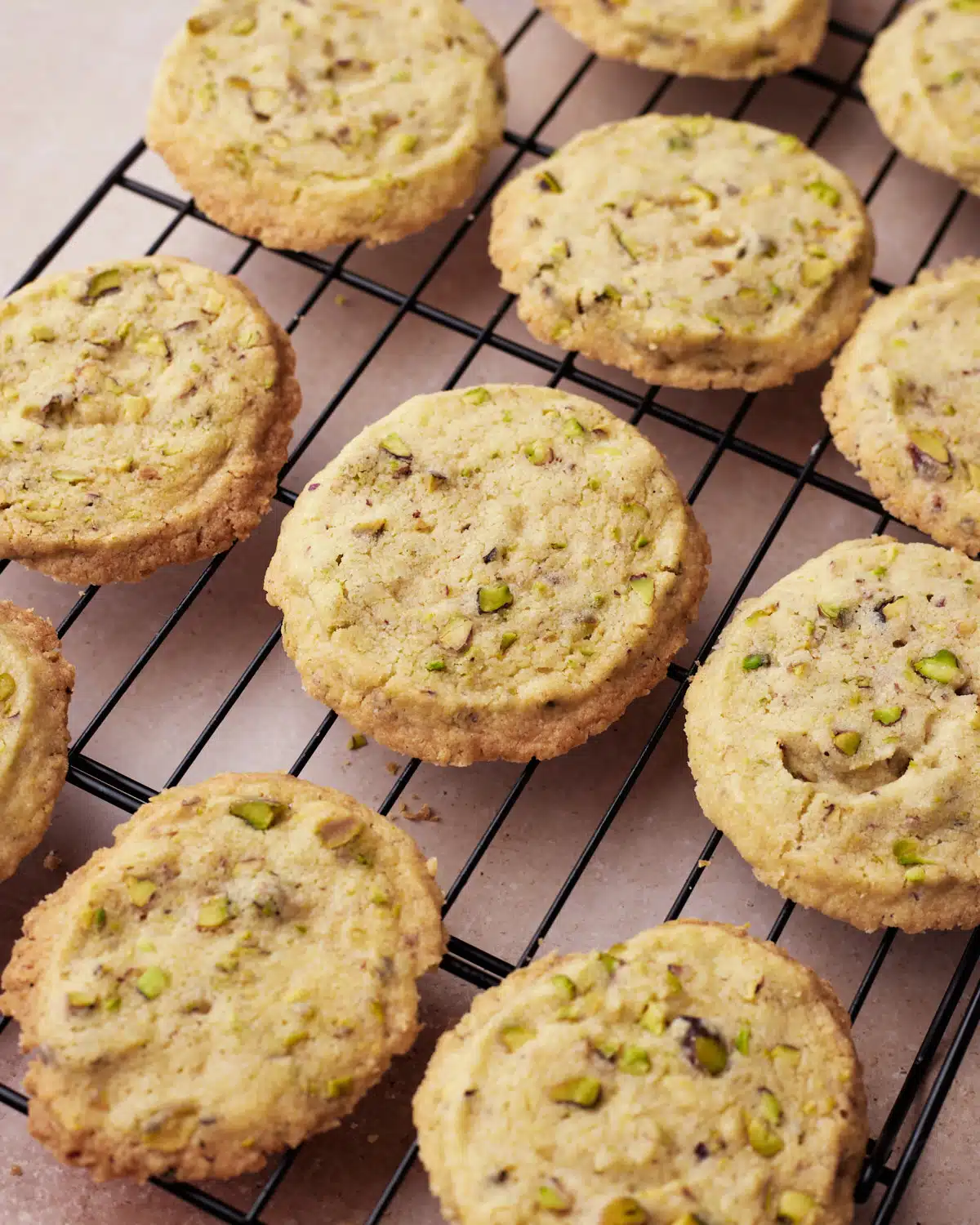 Baked pistachio shortbread cookies cooling on a wire rack. 