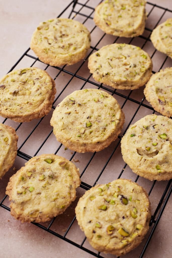 Baked pistachio shortbread cookies cooling on a wire rack.
