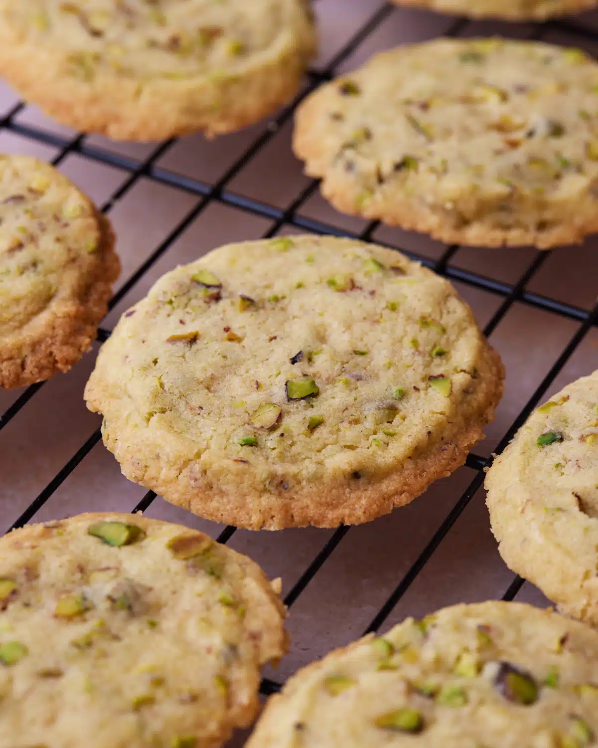 Baked pistachio shortbread cookies cooling on a wire rack.