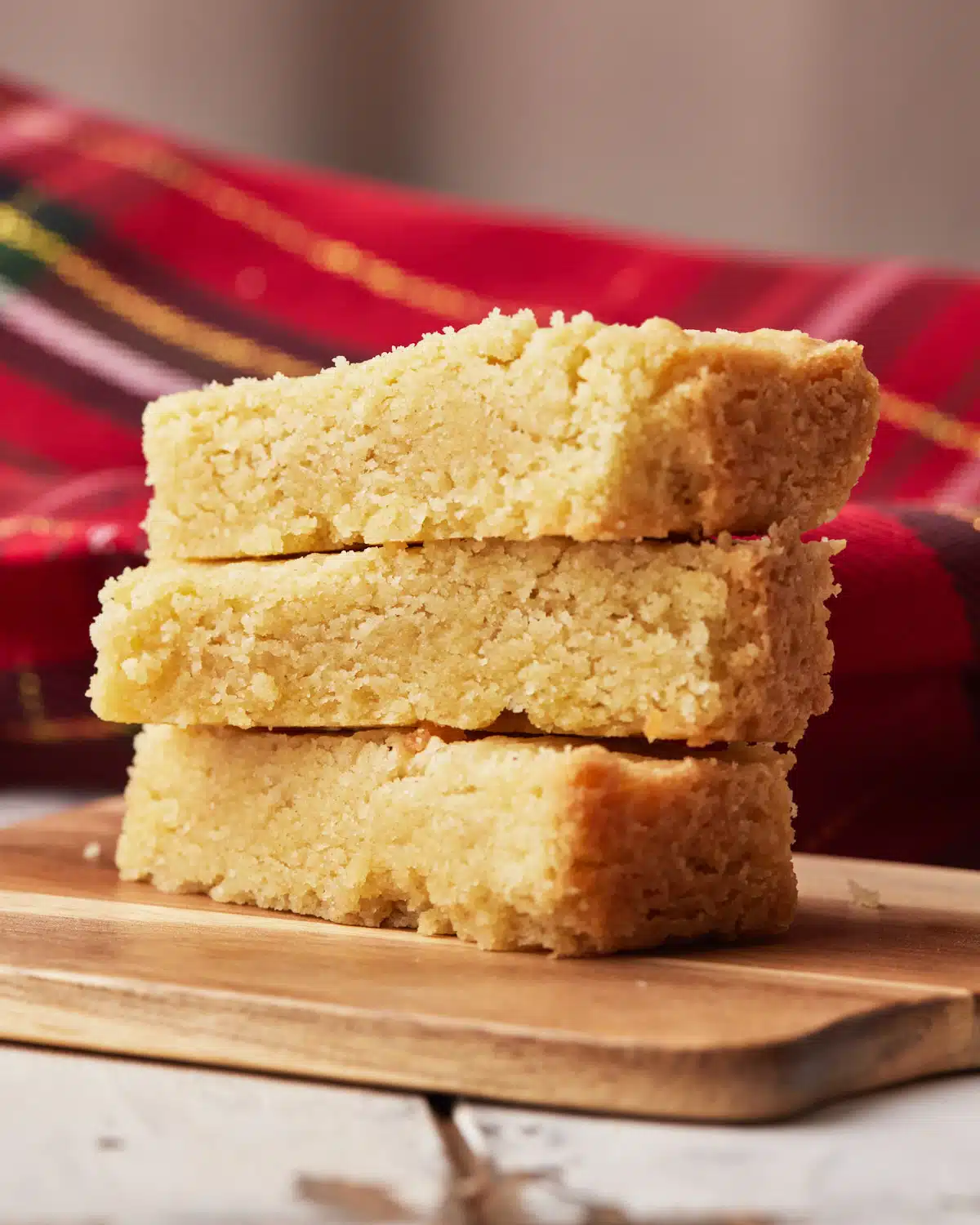 Three fingers of scottish shortbread in a pile showing the soft and crumbly texture. 