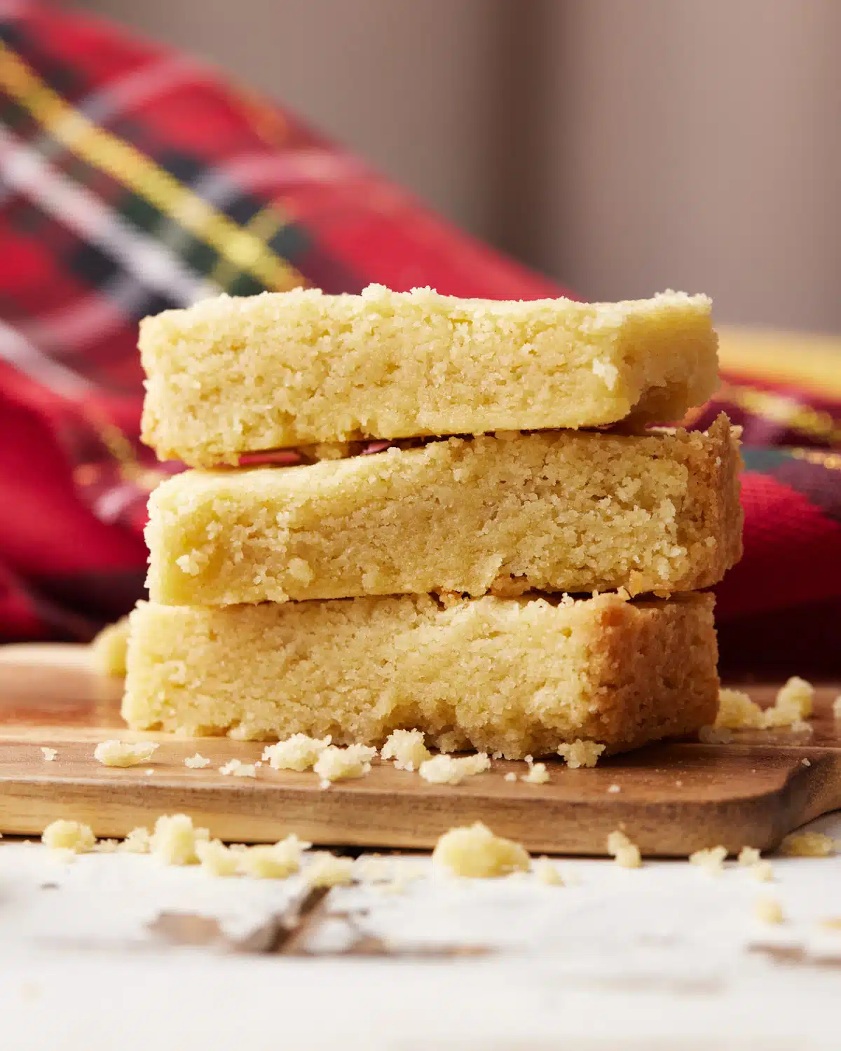 Three fingers of scottish shortbread in a pile showing the soft and crumbly texture.