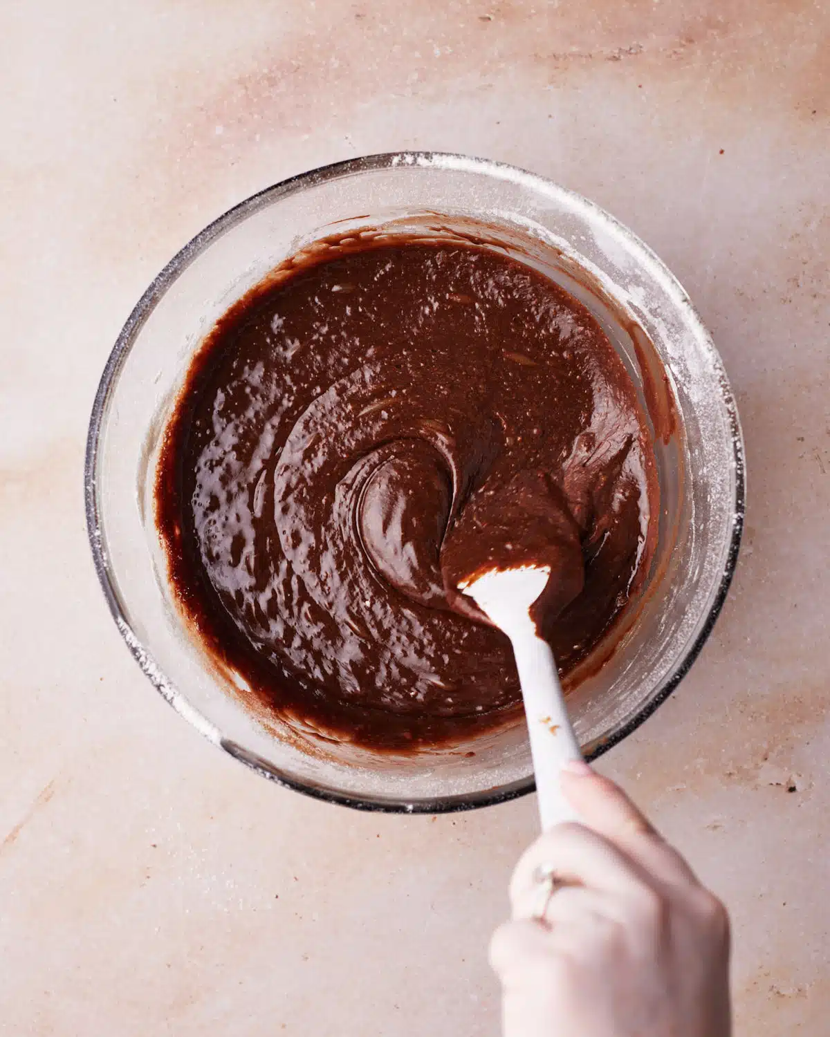 Fudgy chocolate brownie batter in a glass bowl to make s'mores brownies.