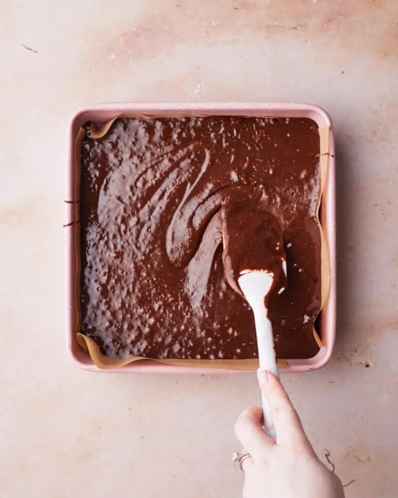 Brownie batter in a square pan, ready to be baked.