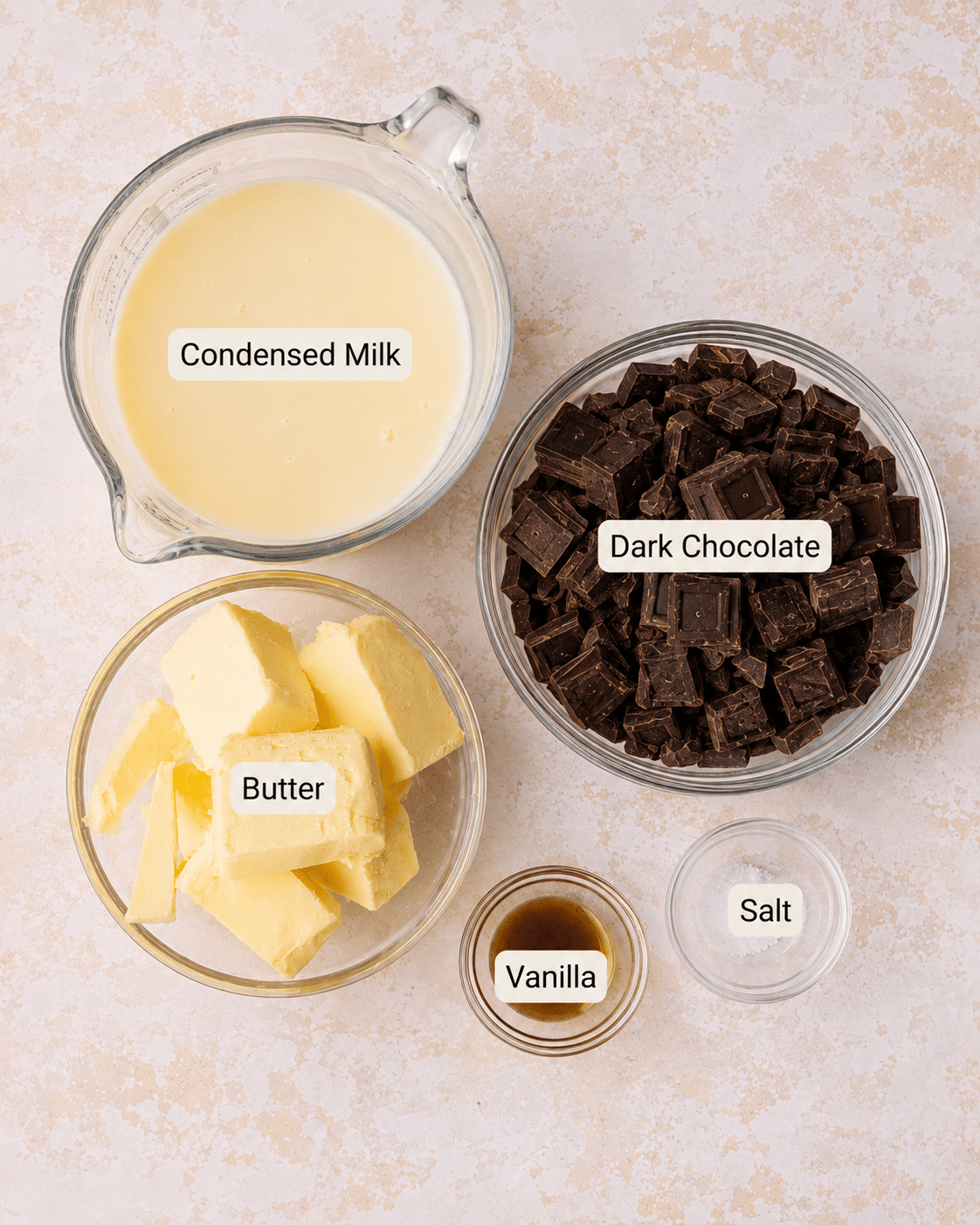 Ingredients for easy chocolate buttercream frosting including sweetened condensed milk, butter, dark chocolate, vanilla, and salt.
