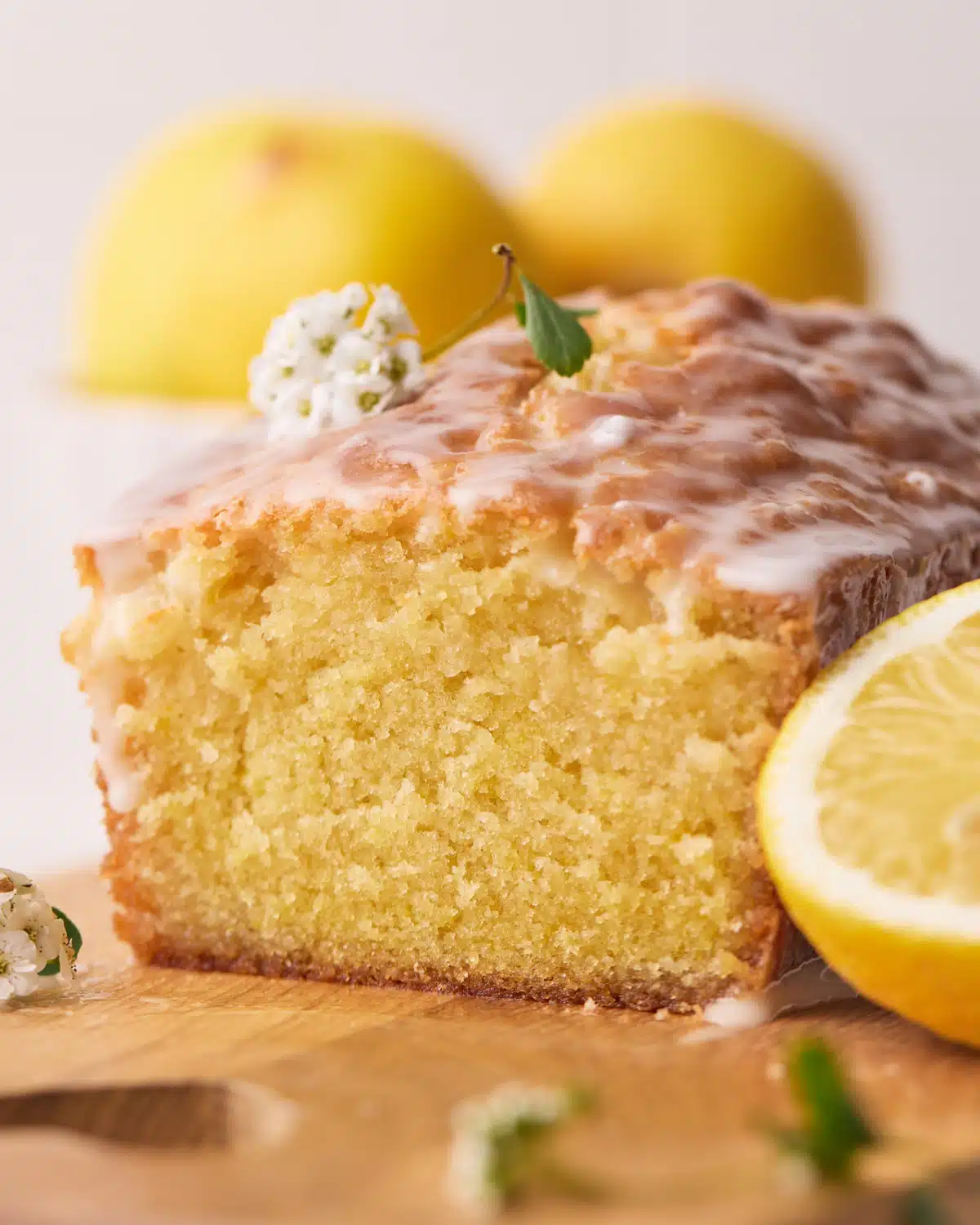 Lemon loaf cake with a slice taken off the end, showing the moist center. 