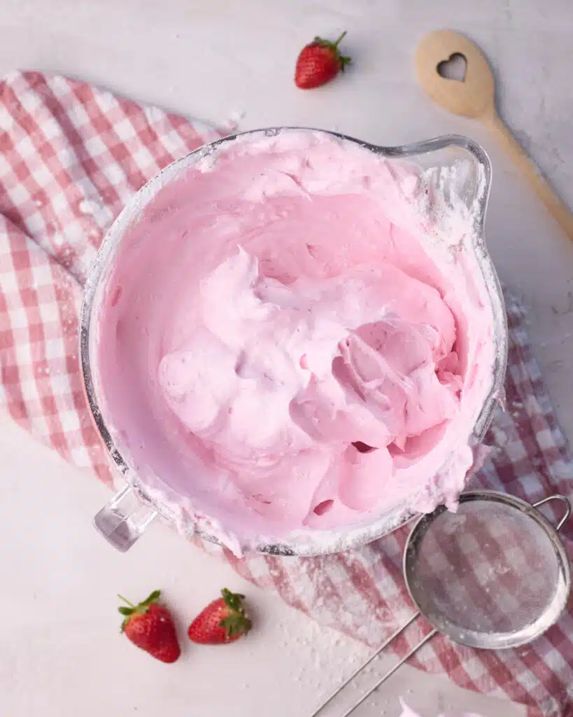 Thick and light strawberry angel food cake batter in a glass bowl.