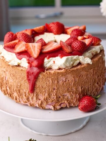 Strawberry angel food cake with whipped cream and fresh strawberries on top.