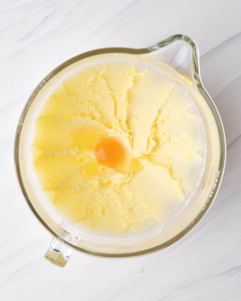 Adding egg to creamed butter and sugar. 