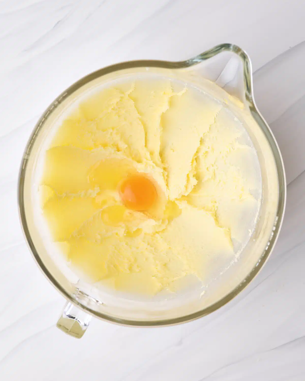 Adding egg to creamed butter and sugar.