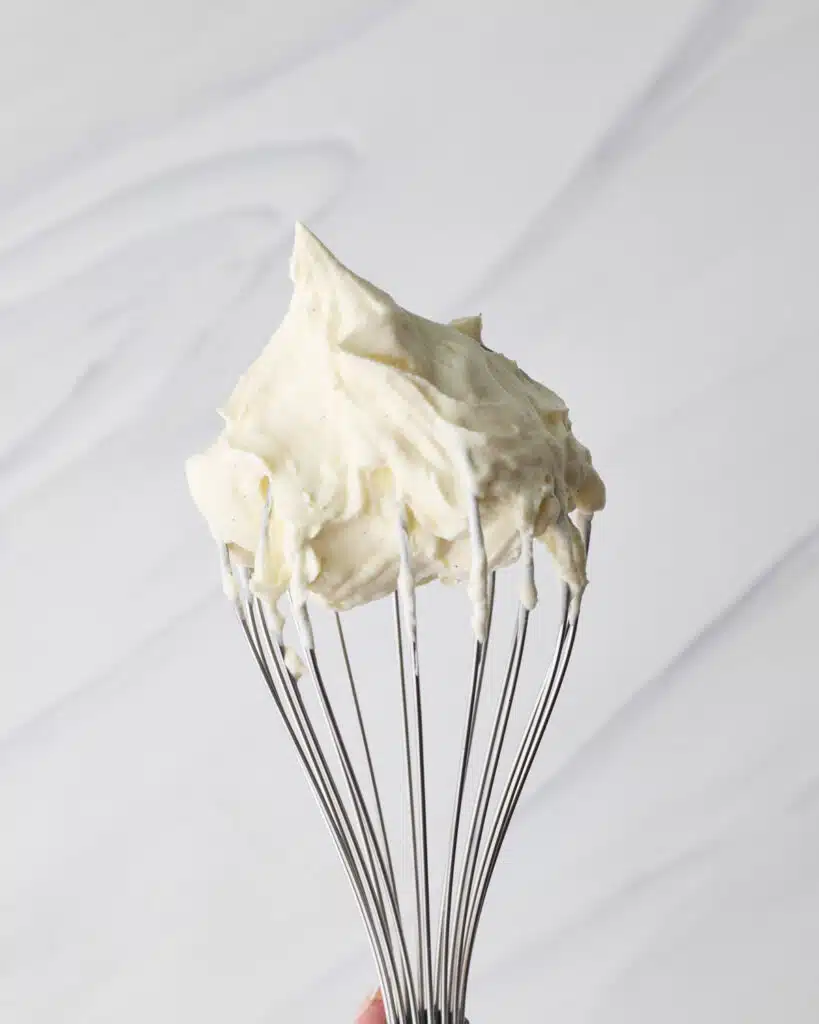 Chantilly cream on a balloon whisk to show soft texture.